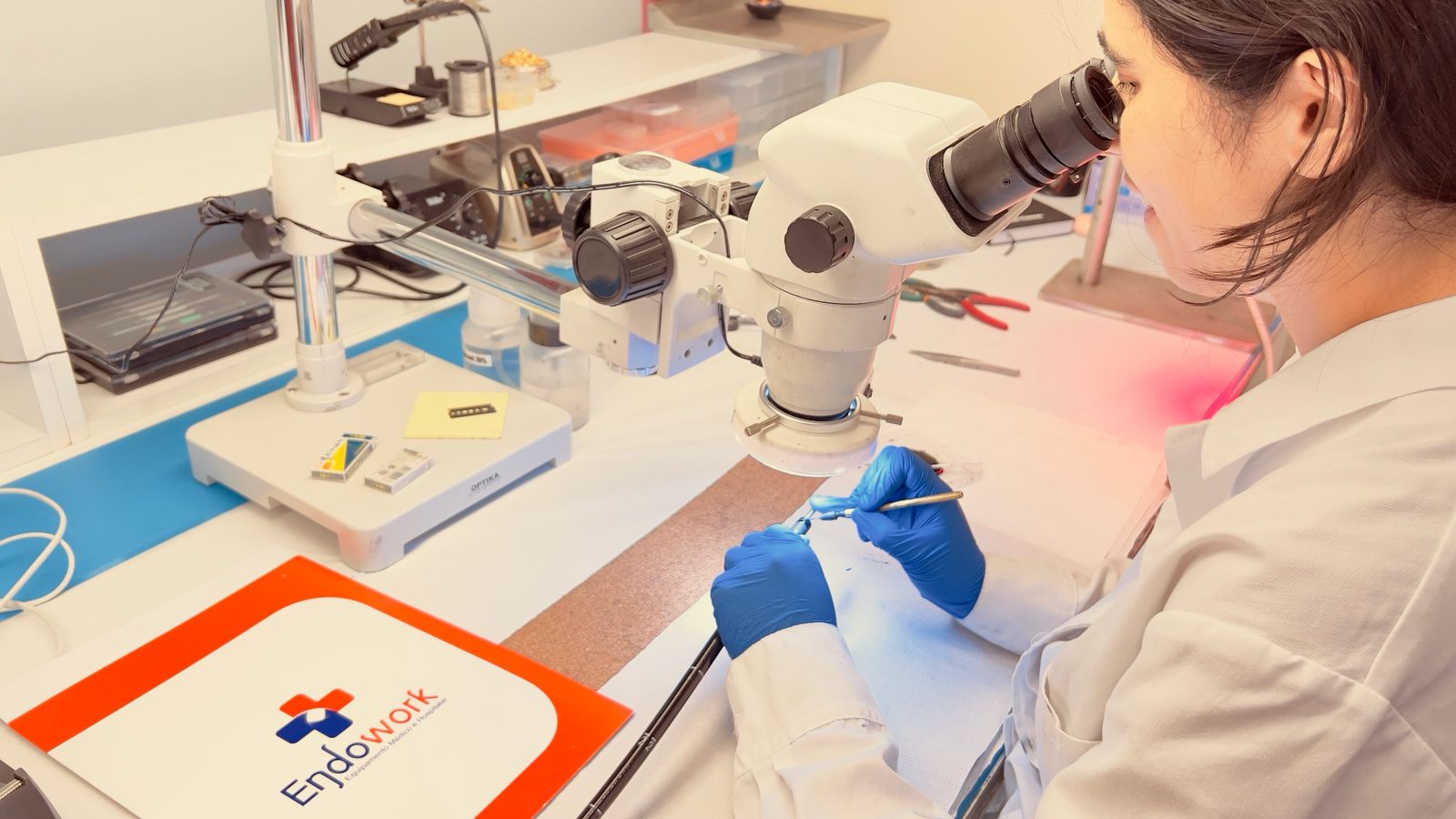 Técnica da Endowork a inspecionar um instrumento médico ao microscópio